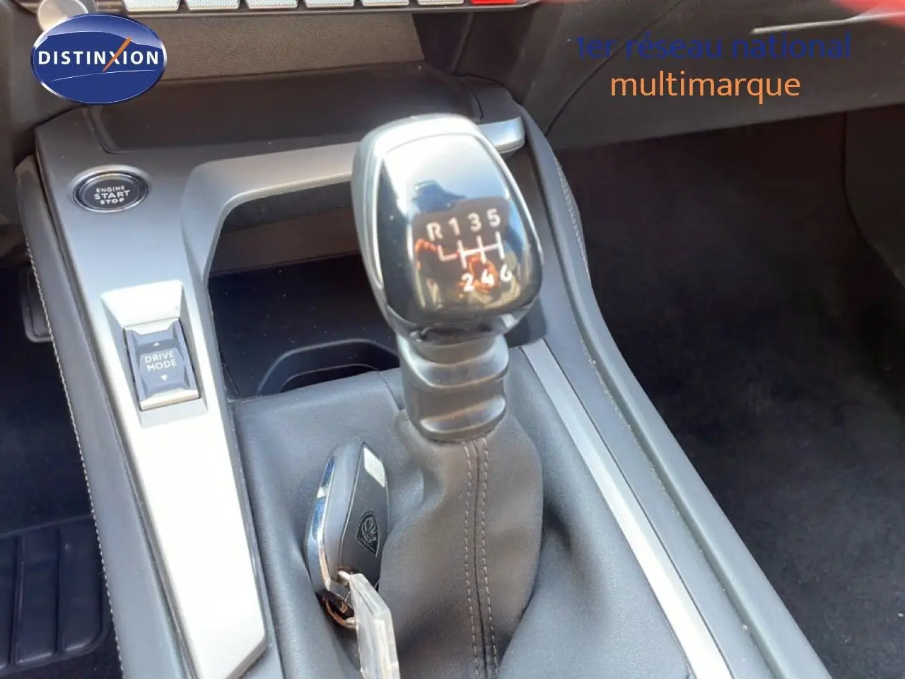Gros plan sur la commande de boîte manuelle et la clé dans la console centrale d'une Peugeot 308 2024.