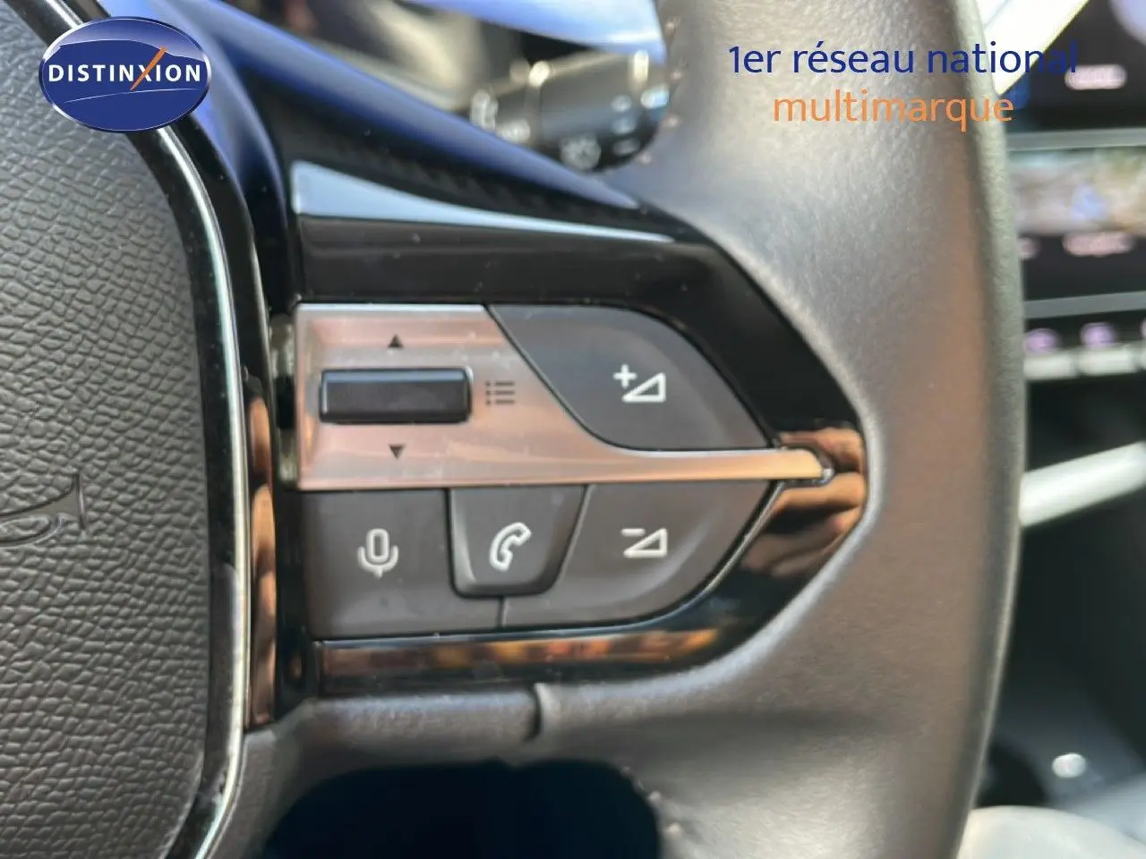 Gros plan sur les commandes au volant en cuir noir de la Peugeot 308 1.2 PureTech 130ch Allure 2024 bleu obsession métal.