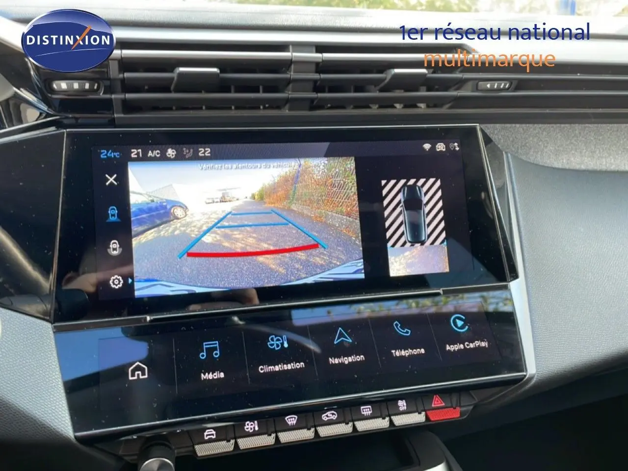 Vue rapprochée de l'écran tactile intérieur de la Peugeot 308 2024 bleu obsession, affichant la caméra de recul et les commandes multimédia.
