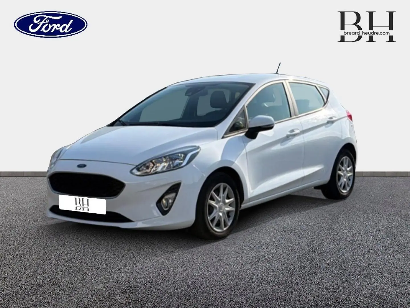Ford Fiesta blanc glacier vue 3/4 avant droit, avec calandre noire et jantes alliage visibles.