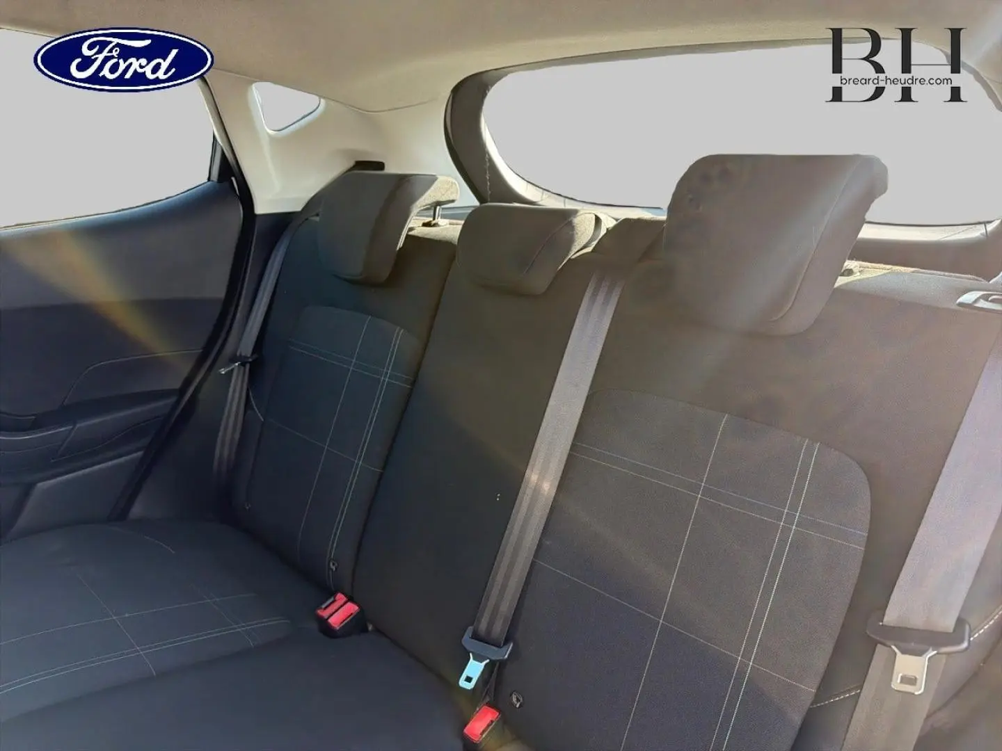 Vue intérieure de la banquette arrière en tissu noir à motifs gris de la Ford Fiesta 2018, avec ceintures de sécurité visibles.