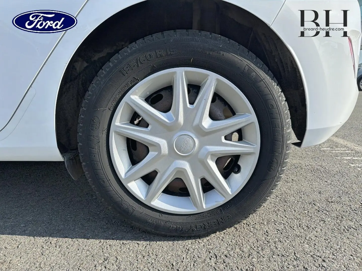 Gros plan sur la roue arrière droite d'une Ford Fiesta blanche avec enjoliveur argenté et pneu Michelin.