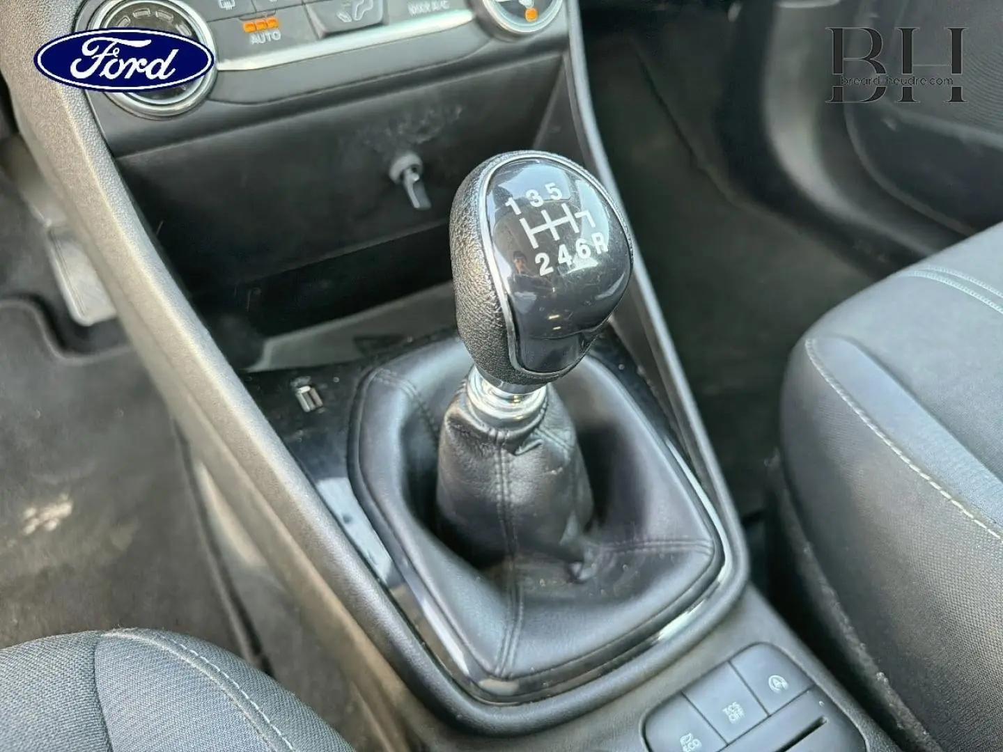 Gros plan sur le levier de vitesses manuel noir de la Ford Fiesta 2018, avec sièges tissu gris visibles autour.