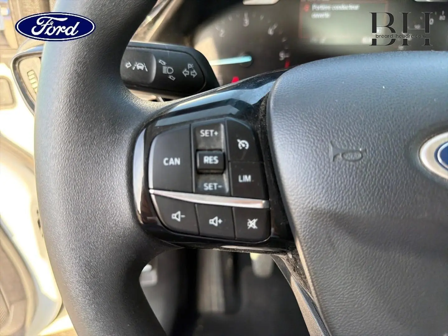 Gros plan sur le volant noir de la Ford Fiesta 2018, montrant les commandes de régulateur de vitesse et audio à gauche.