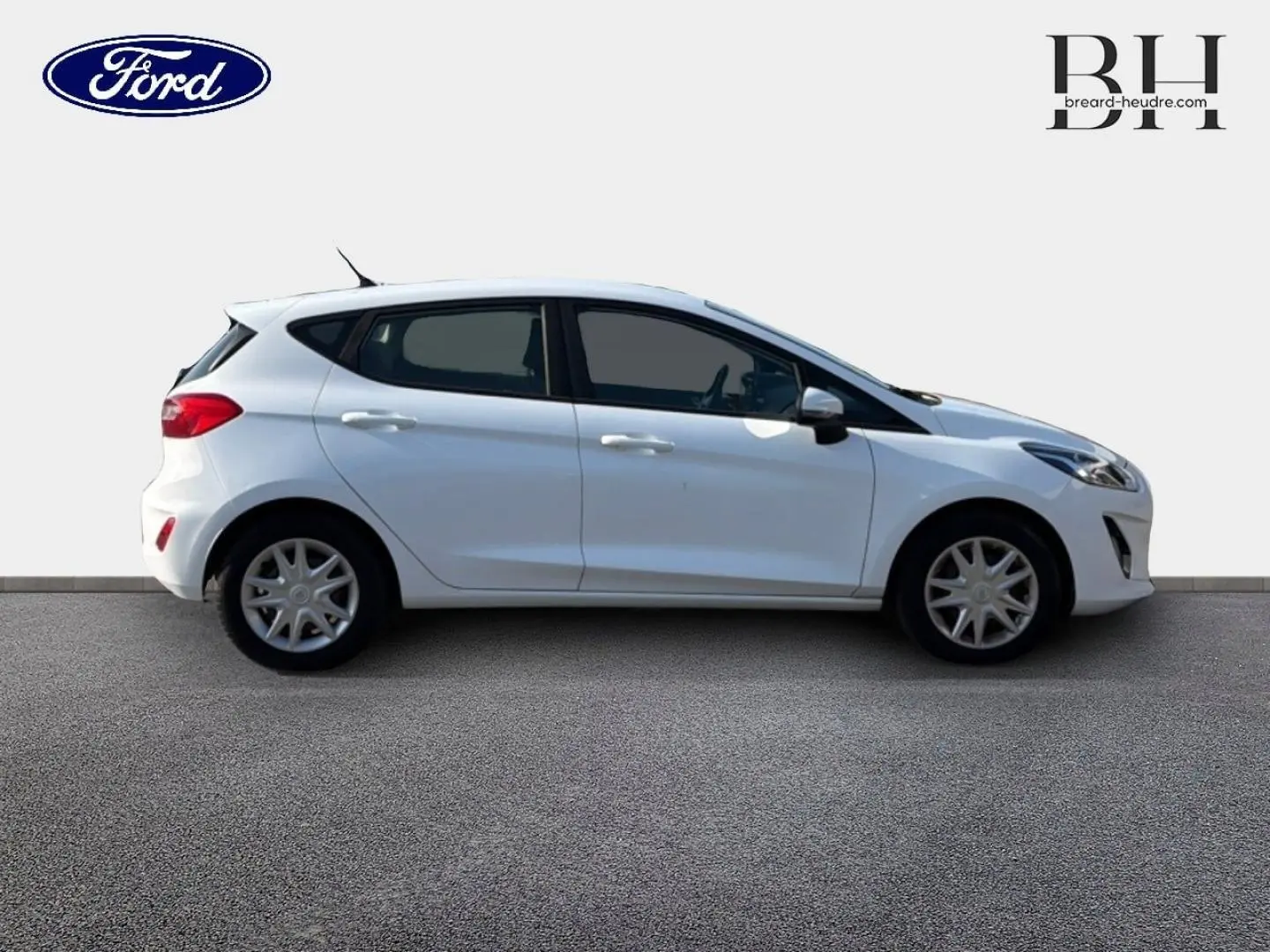 Vue de profil côté gauche d'une Ford Fiesta blanche Glacier 5 portes avec enjoliveurs et becquet arrière.