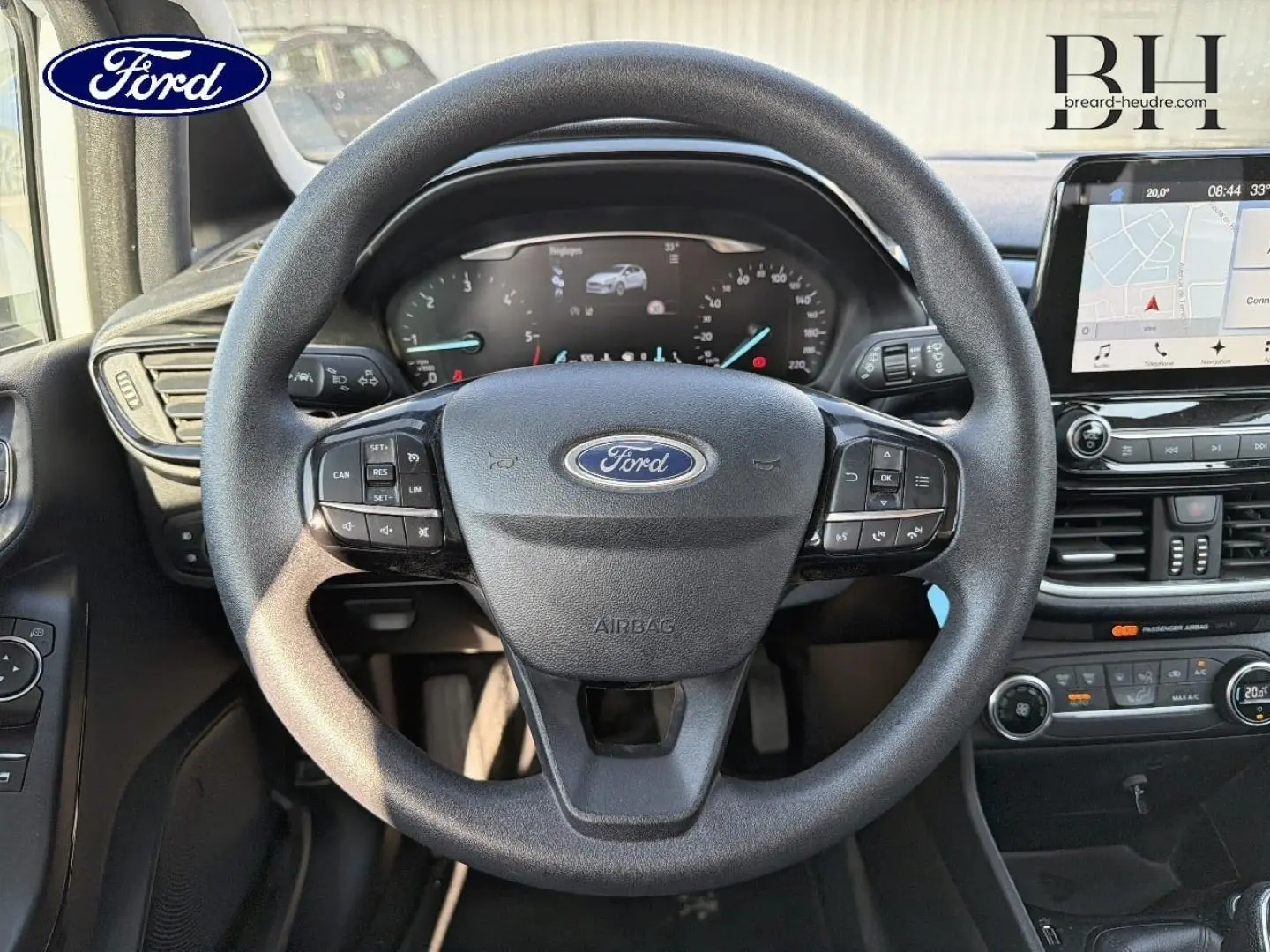 Vue intérieure centrée sur le volant noir de la Ford Fiesta 2018 avec tableau de bord numérique et écran tactile GPS.