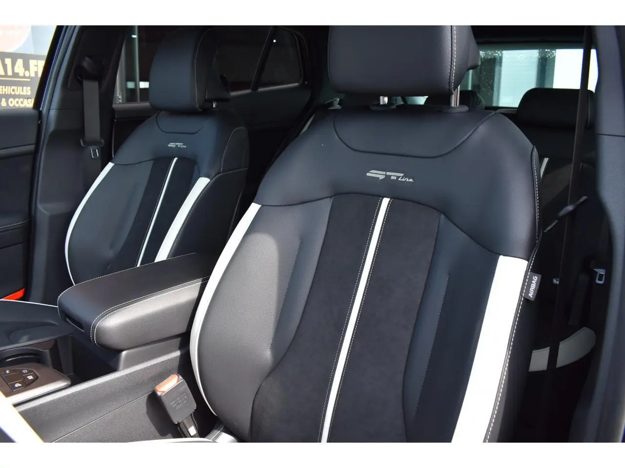 Gros plan sur les sièges avant bi-ton noir et gris du Kia Sportage GT-Line hybride 2026 avec logo GT-Line brodé.