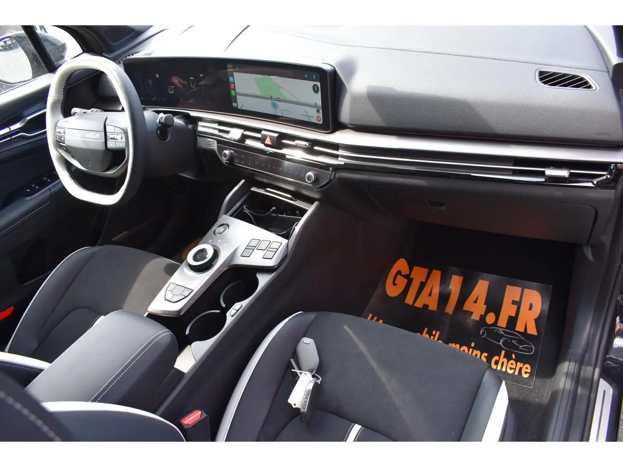 Vue intérieure côté conducteur du Kia Sportage 2026 hybride, avec tableau de bord digital et console centrale moderne.