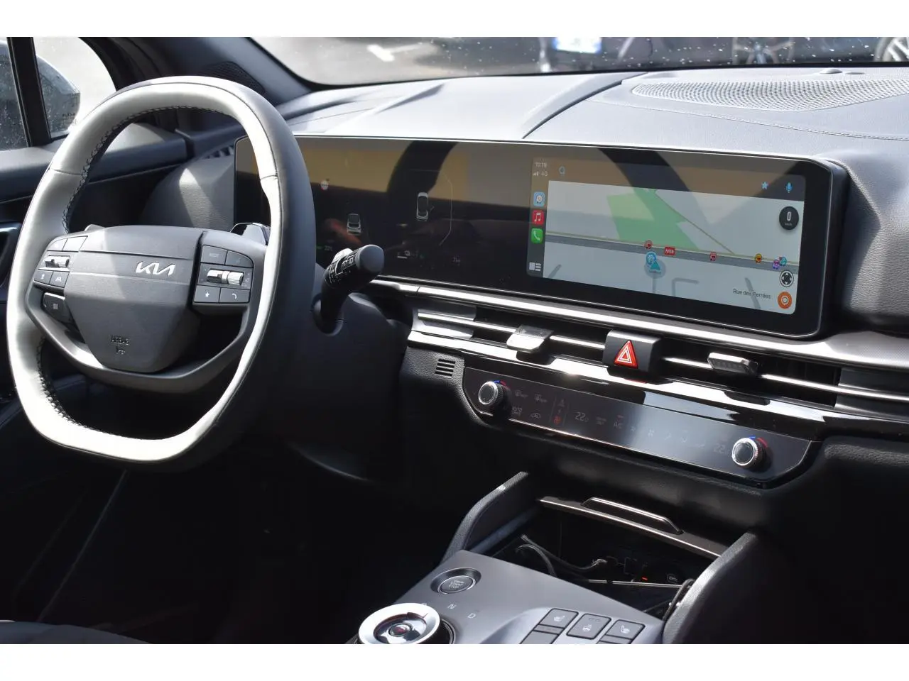 Vue intérieure du tableau de bord du Kia Sportage noir 2026, avec écran tactile large et volant multifonction.