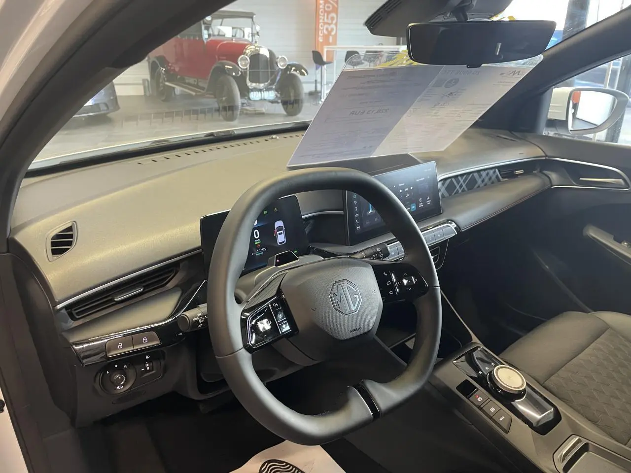Vue intérieure côté conducteur du MG3 1.5 Hybrid+ blanc, volant multifonction et écran tactile central visibles.