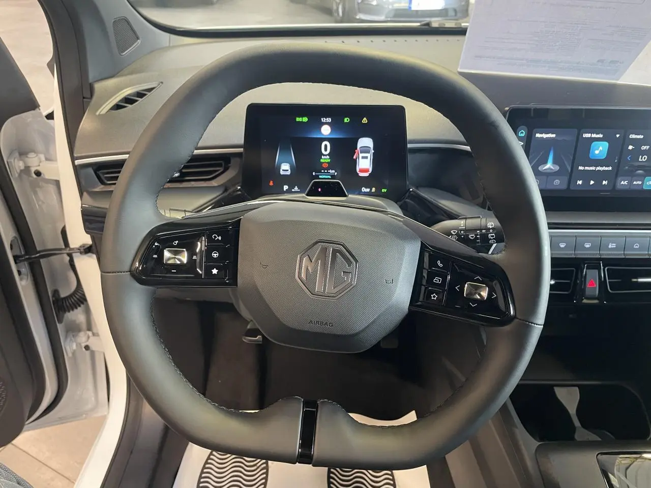 Vue frontale du volant noir de la MG3 1.5 Hybrid+ 195 Luxury blanche, avec tableau de bord numérique et écran tactile visible.
