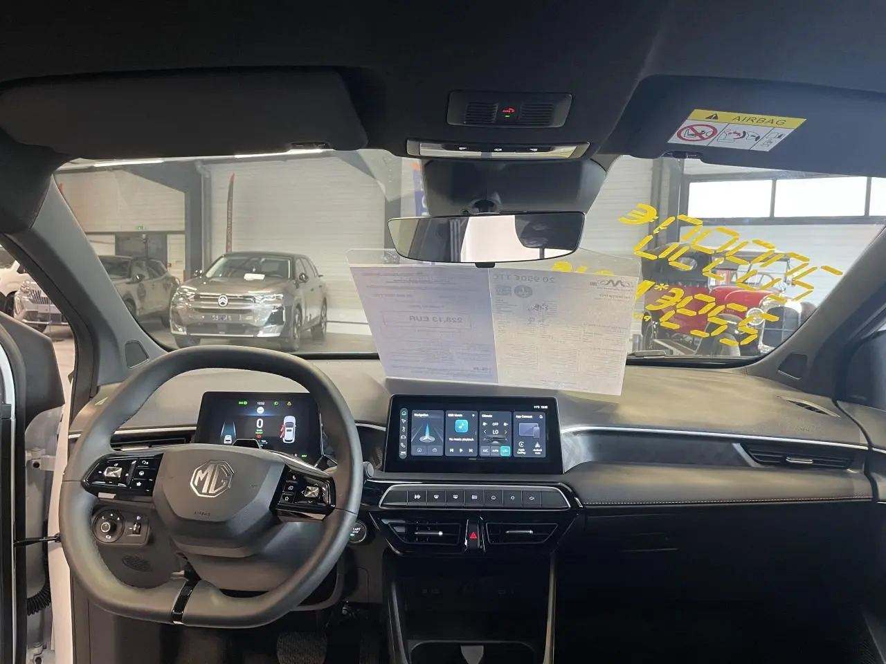 Vue intérieure avant du tableau de bord du MG3 1.5 Hybrid+ 2026 avec écran tactile et volant multifonction noir.