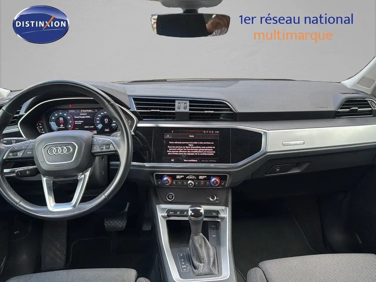 Intérieur d'Audi Q3 Sportback blanc 2021, vue frontale du tableau de bord avec écran tactile et volant multifonction.