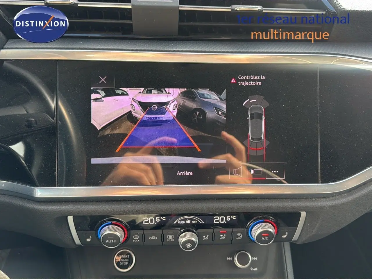 Écran central affichant la caméra de recul avec alertes, dans l'habitacle d'un Audi Q3 Sportback blanc 2021.