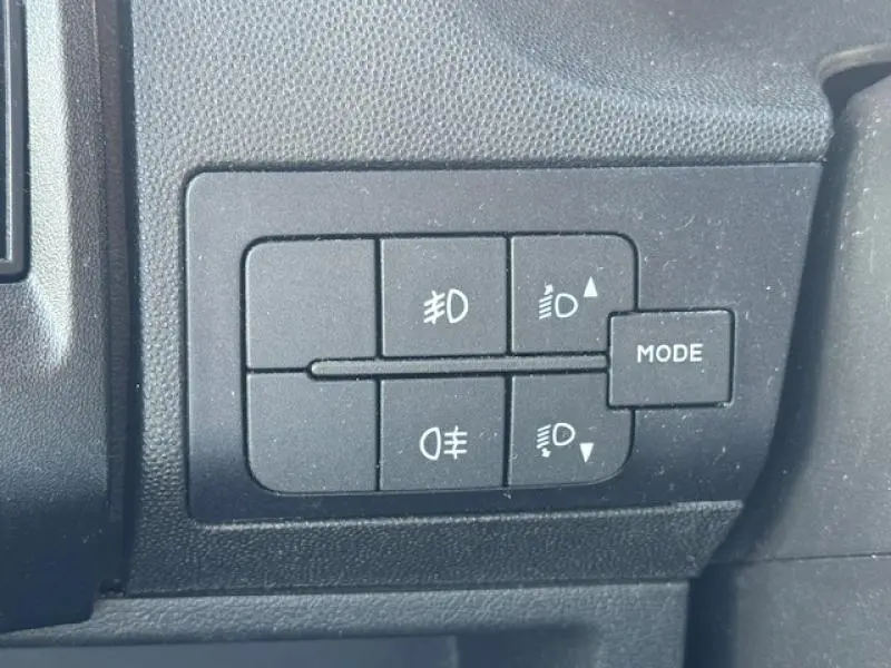 Panneau de commandes des phares et mode sur tableau de bord noir du Peugeot Boxer Fourgon blanc Banquise.