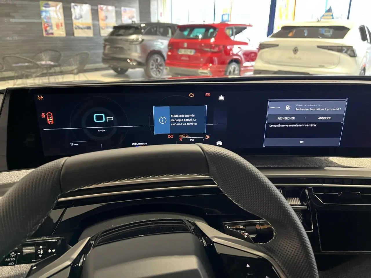 Vue intérieure du tableau de bord et volant du Peugeot 3008 gris titanium 2025, avec écran numérique panoramique allumé.