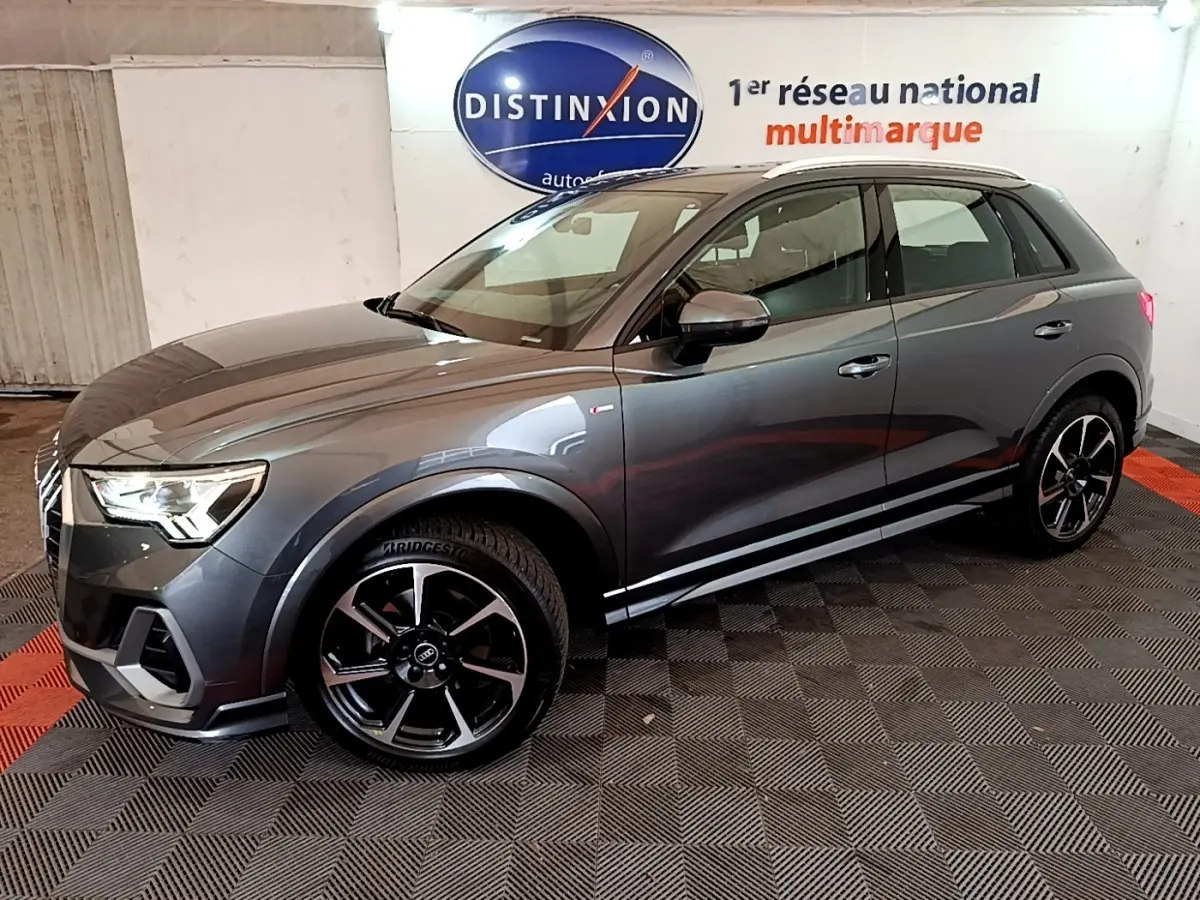 Audi Q3 35 TFSI S Line gris foncé, vue 3/4 avant droit, avec jantes noires et détails S Line visibles.