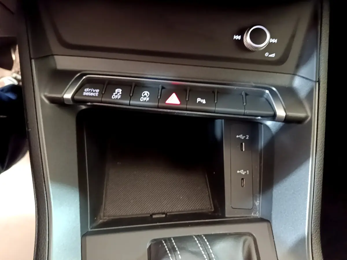 Vue rapprochée de la console centrale noire de l'Audi Q3 35 TFSI 2022 avec boutons de contrôle et ports USB.
