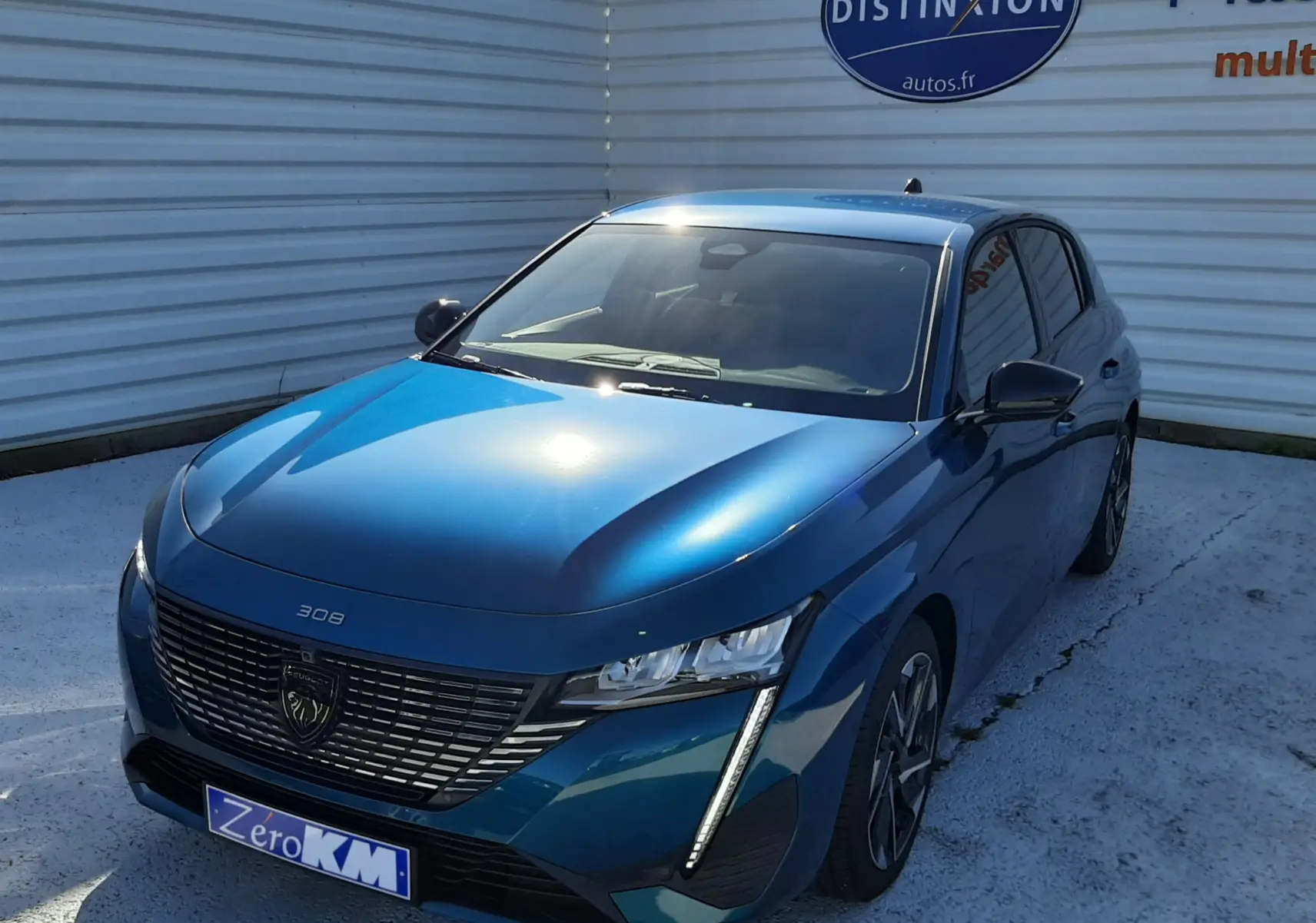 Peugeot 308 Bleu Obsession vue 3/4 avant droit, avec calandre noire distinctive et feux LED verticaux allumés.