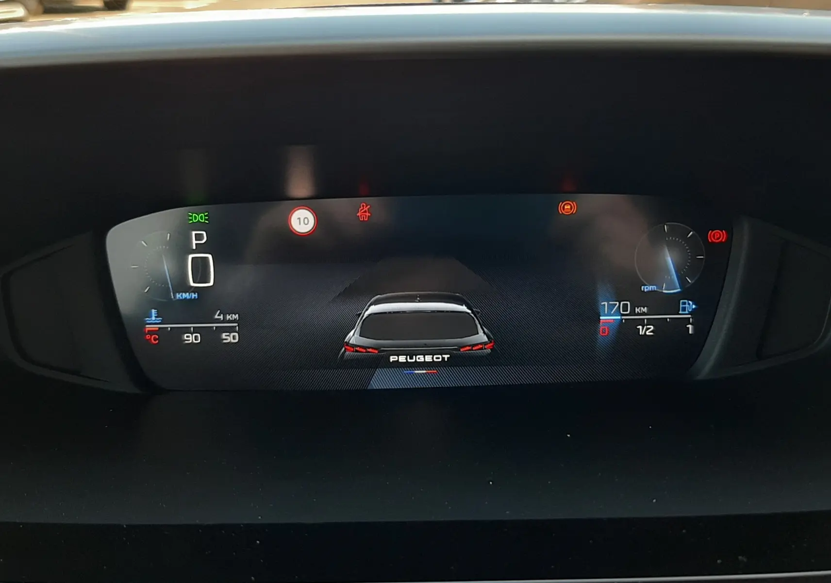 Affichage numérique du tableau de bord de la Peugeot 308, montrant un véhicule vu de l'arrière et les indicateurs de vitesse et carburant.