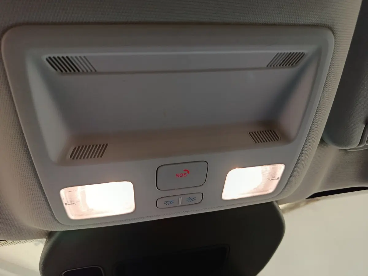 Vue intérieure du plafonnier gris clair du Ford Kuga 2023 avec éclairages et bouton SOS allumé.