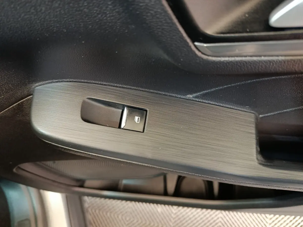 Gros plan sur la commande de lève-vitre côté conducteur du Ford Kuga gris foncé, finition Titanium 2023.