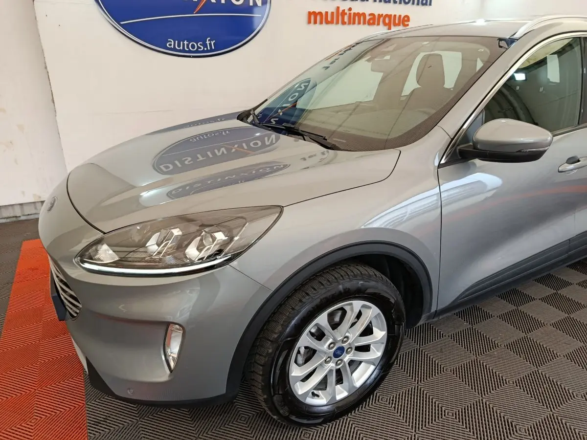 Vue 3/4 avant droit d’un Ford Kuga gris foncé 2023 avec jantes alliage et phares LED ellipsoïdaux.