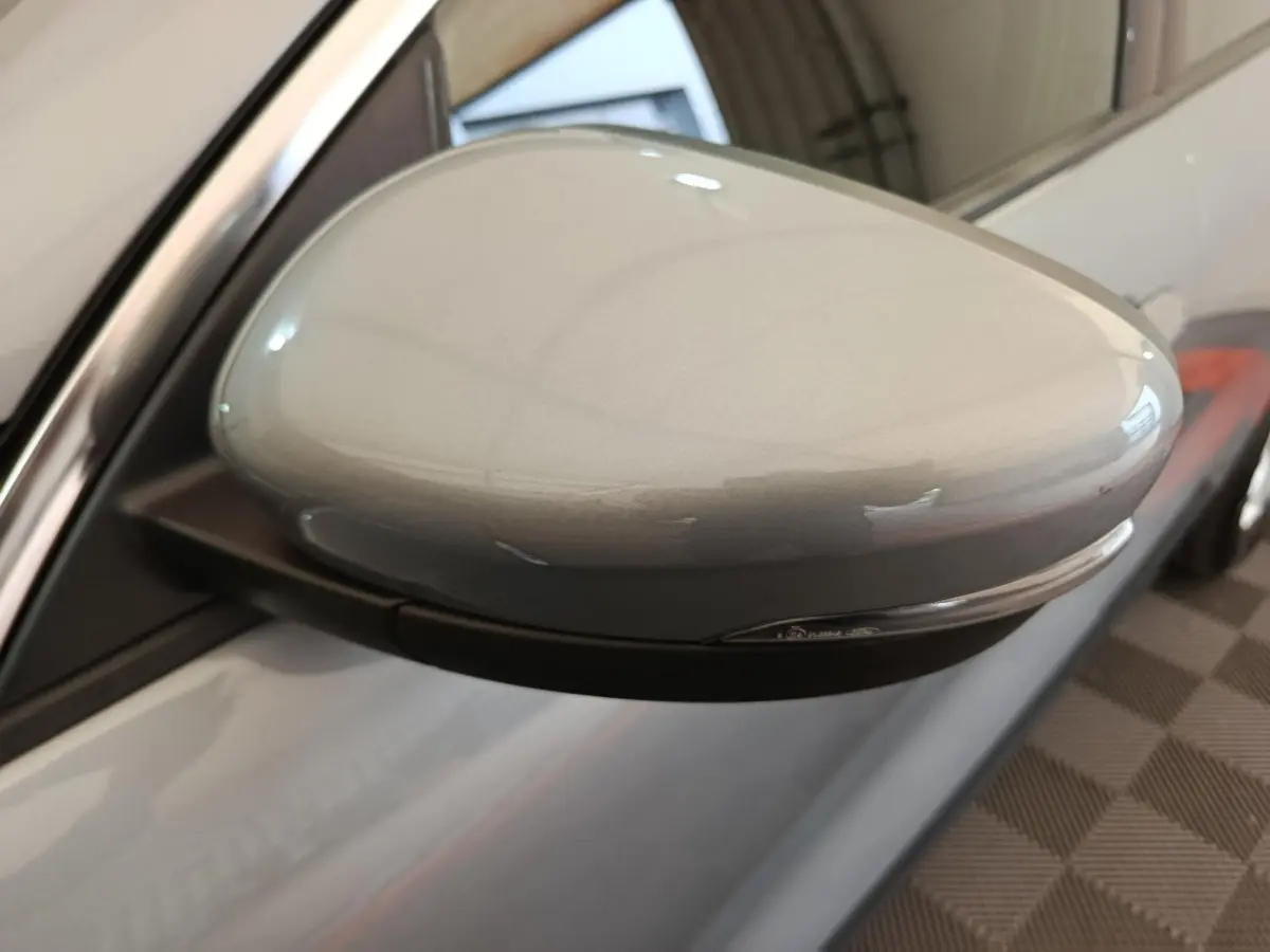 Rétroviseur côté gauche gris foncé du Ford Kuga 2023 avec clignotant intégré, vue rapprochée en intérieur.