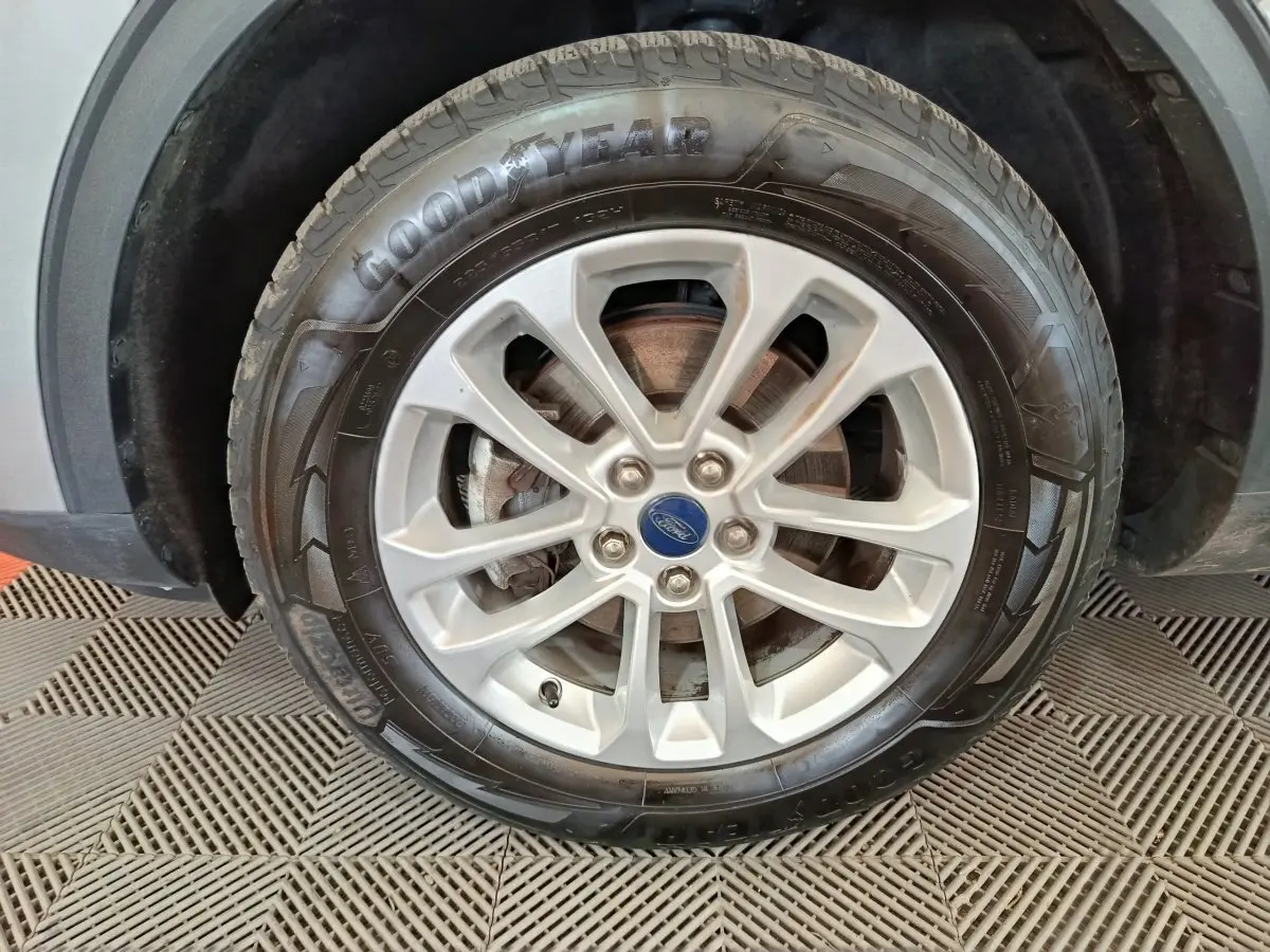 Gros plan sur la roue avant gauche du Ford Kuga gris foncé, avec jante alliage et pneu Goodyear visible.