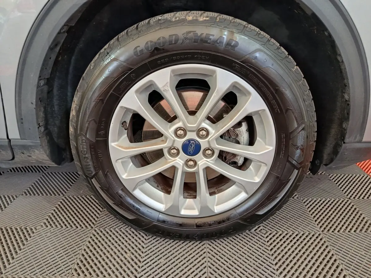 Gros plan sur la roue avant droite gris foncé du Ford Kuga 2.5 190 hybrid Flexifuel avec jante alliage et pneu Goodyear.