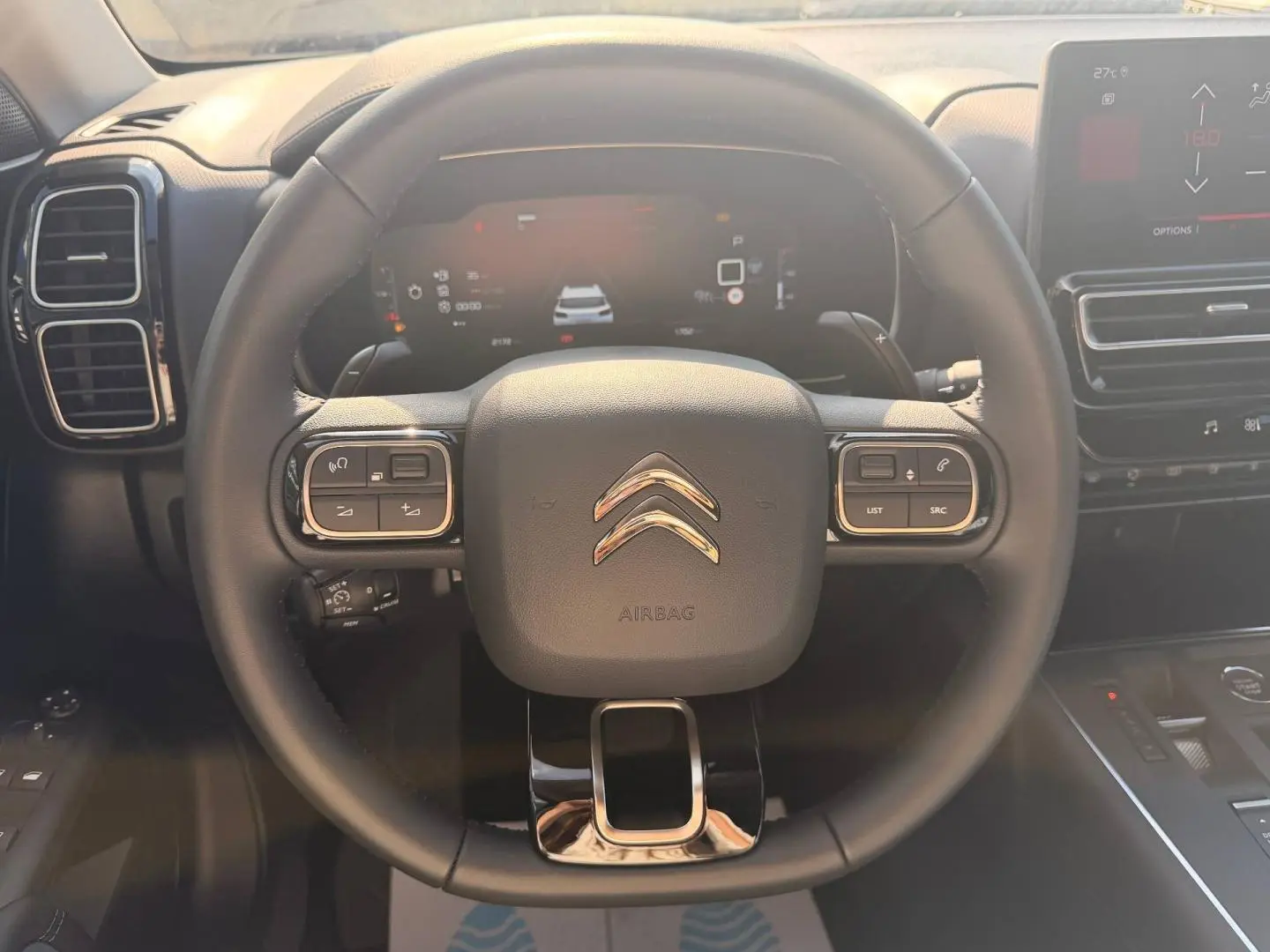 Vue frontale du volant cuir noir multifonction du Citroën C5 Aircross 2025 avec tableau de bord digital et écran tactile.