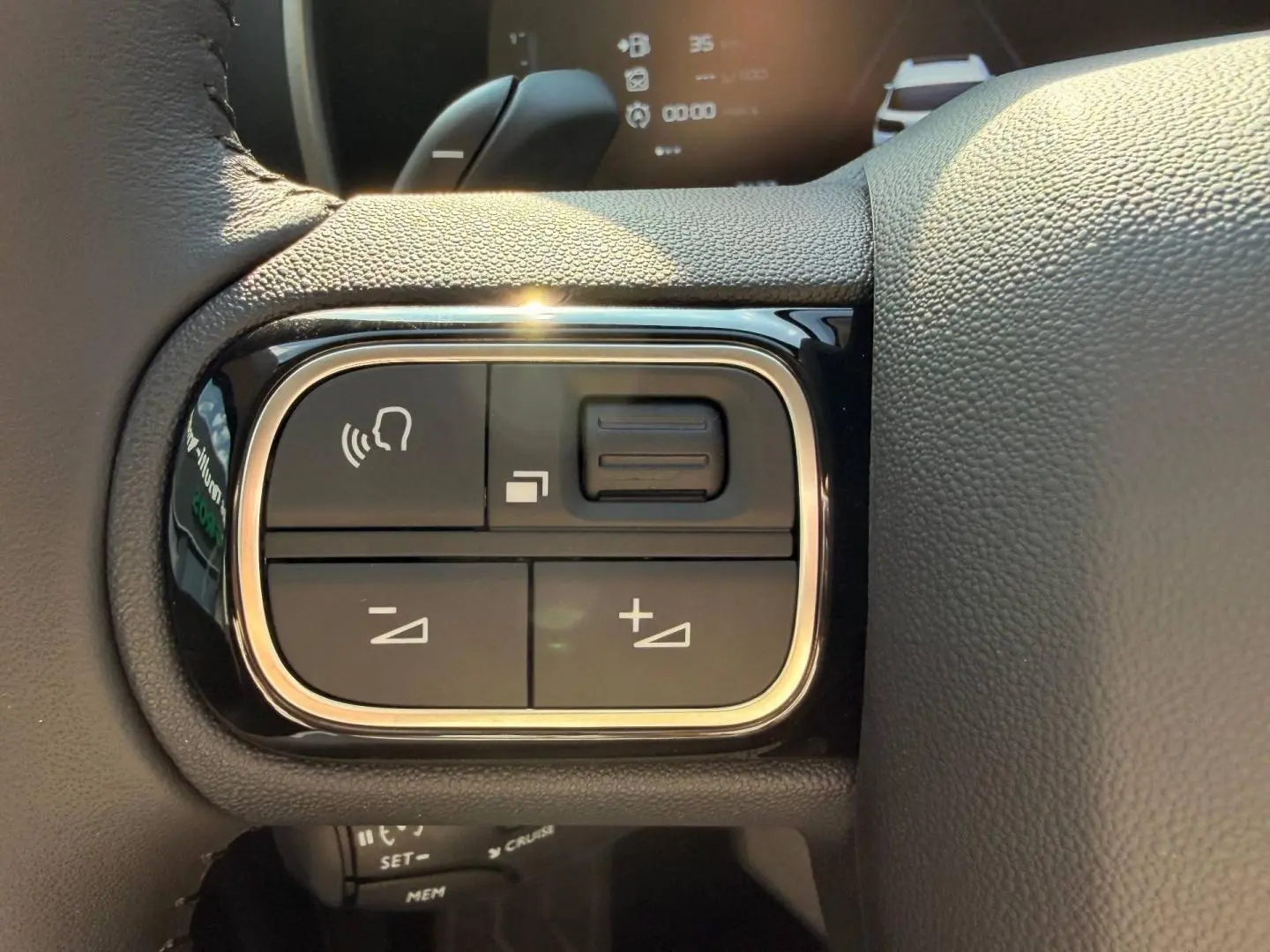 Gros plan sur les commandes vocales et volume au volant cuir du Citroën C5 Aircross gris Platinium 2025.