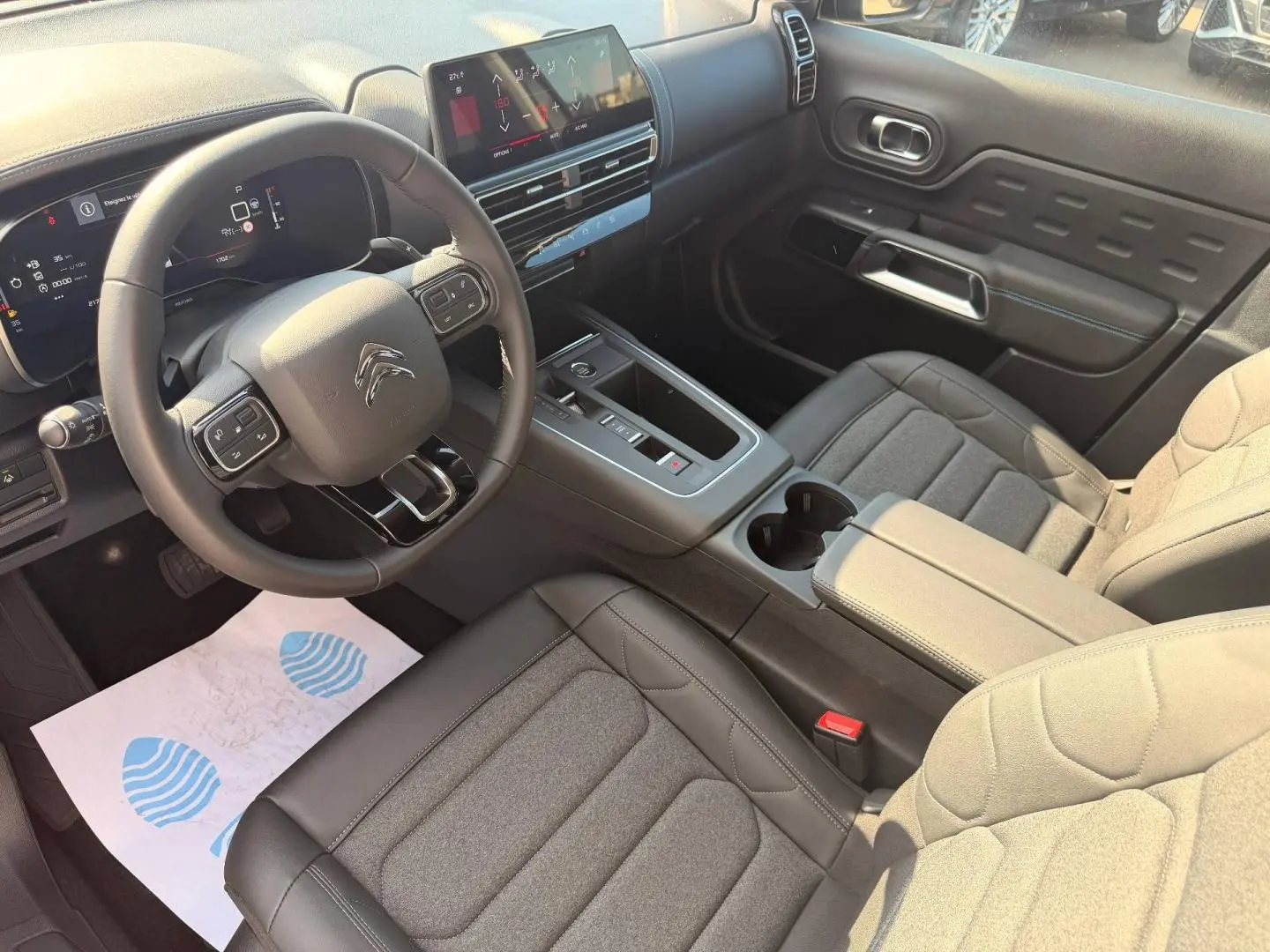 Intérieur avant du Citroën C5 Aircross 2025, vue côté conducteur, sièges tissu noir et tableau de bord moderne.