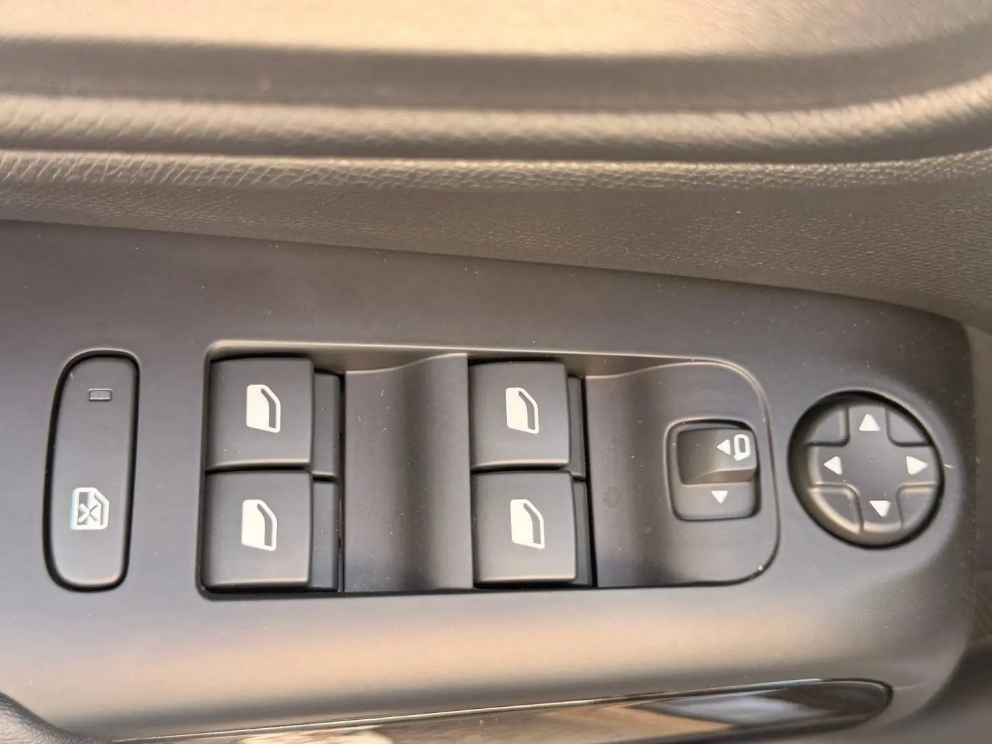 Gros plan sur les commandes de lève-vitres et réglages des rétroviseurs côté conducteur du Citroën C5 Aircross gris Platinium.