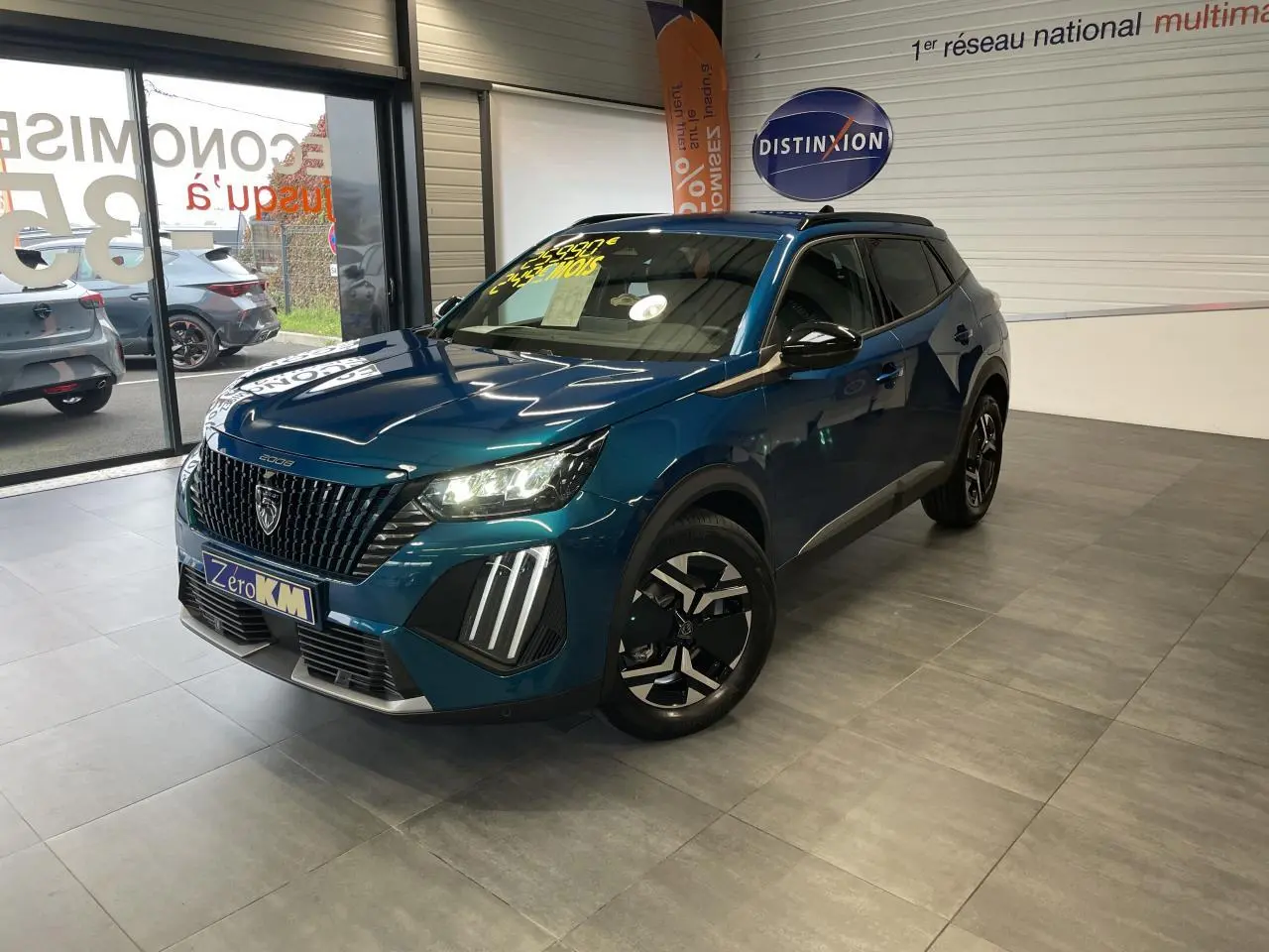 Peugeot 2008 bleu 3/4 avant droit en showroom avec calandre noire et feux LED griffes allumés.