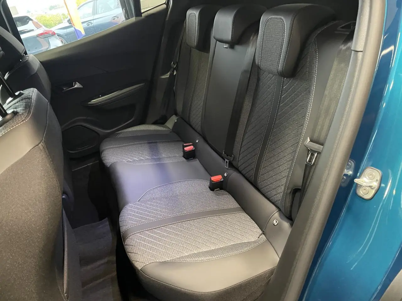 Vue intérieure côté droit des sièges arrière en tissu et cuir noir d’un Peugeot 2008 bleu 2026.