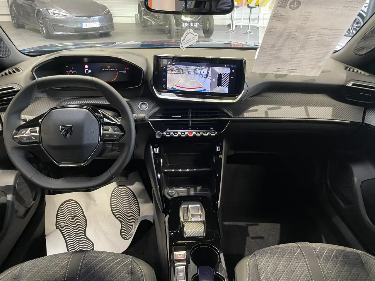 Vue intérieure avant du Peugeot 2008 2026, tableau de bord noir avec écran tactile et volant compact cuir.
