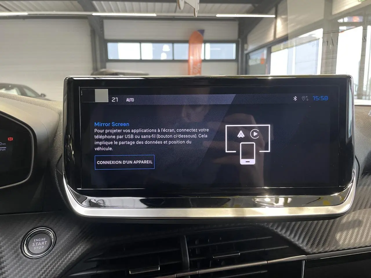 Écran tactile central du Peugeot 2008 hybride 2026 avec interface Mirror Screen et bouton start/stop à gauche.
