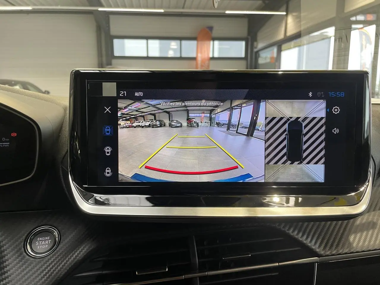 Écran tactile intérieur affichant la caméra de recul et vue 360° du Peugeot 2008 hybride bleu en stationnement.