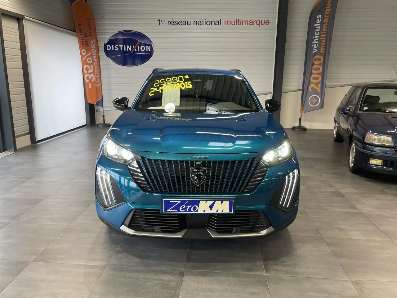 Vue frontale d'un Peugeot 2008 bleu métallisé avec feux LED allumés et calandre noire brillante en showroom.