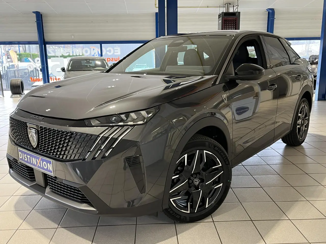 Peugeot 3008 GT gris titanium en 3/4 avant droit, avec calandre noire laquée et jantes alliage 19'' diamantées.