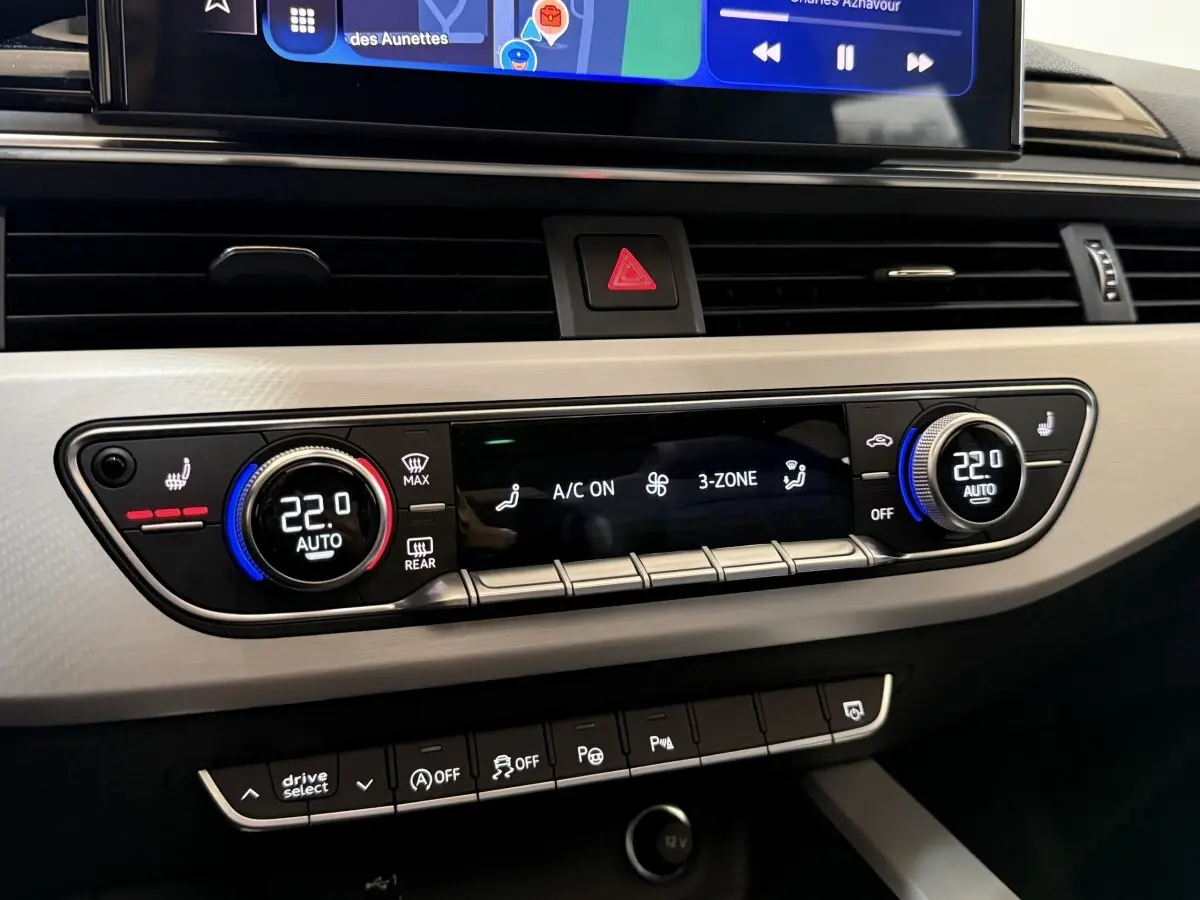 Détail du tableau de bord de l’Audi A4 gris foncé 2022, montrant la climatisation automatique 3 zones et les commandes tactile.
