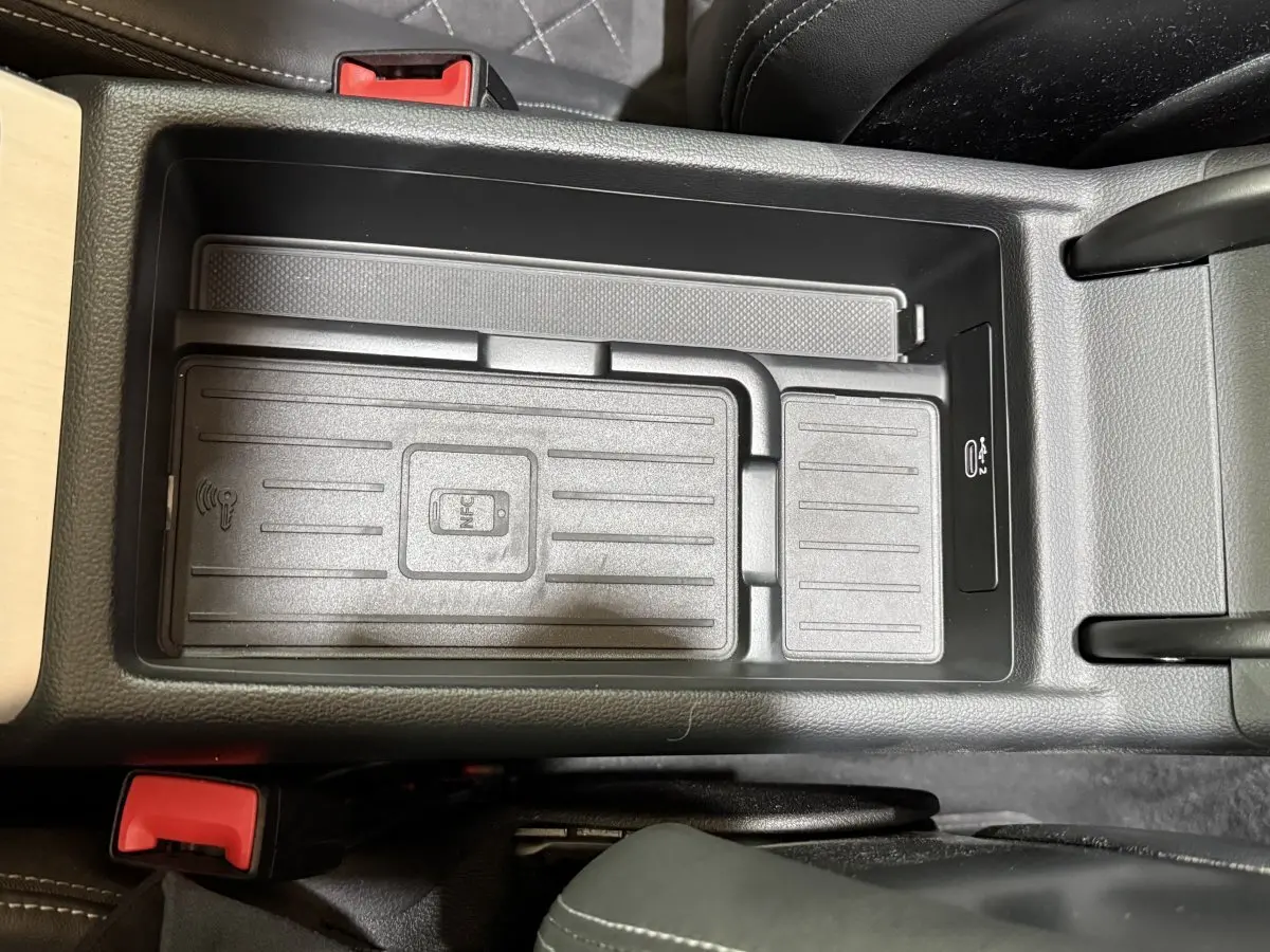 Vue plongeante sur la zone de recharge sans fil noire au centre de l'habitacle de l'Audi A4 gris foncé.