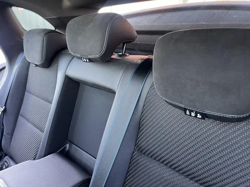 Vue rapprochée de la banquette arrière noire étoilée du Renault Austral 2023 avec appuie-têtes en alcantara et surpiqûres bleues.