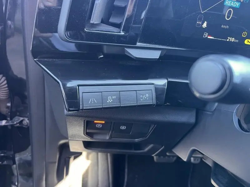 Gros plan sur les commandes d'aide à la conduite côté gauche du tableau de bord noir étoilé du Renault Austral 2023.