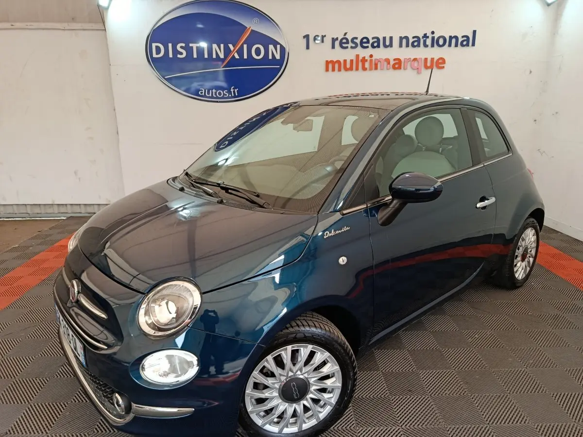 Vue 3/4 avant droite d'une Fiat 500 Dolcevita bleue avec jantes alliage et logo distinctif sur l'aile avant.