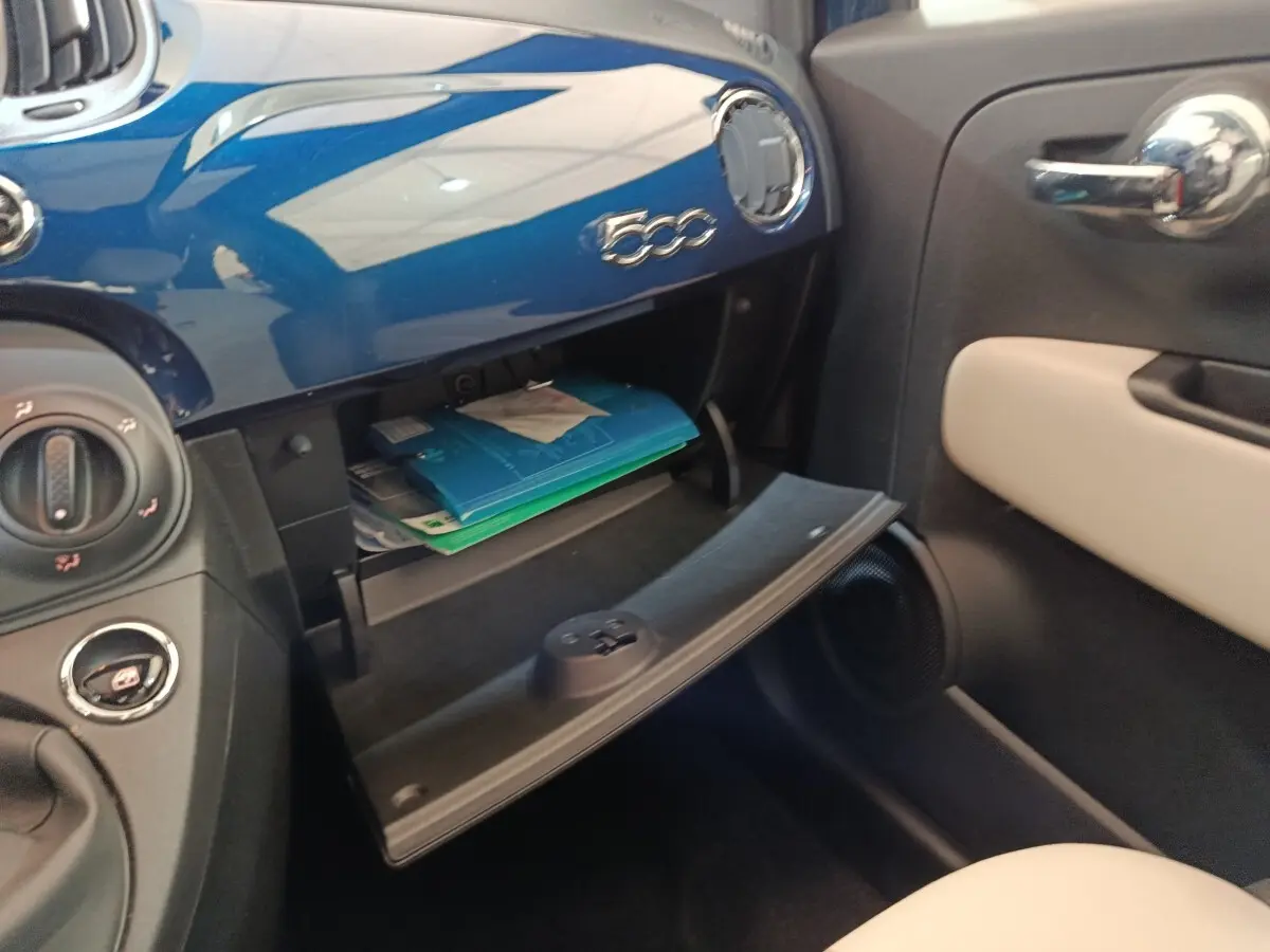Vue intérieure côté passager du coffre à gants ouvert sur tableau de bord bleu brillant de la Fiat 500 Dolcevita 2022.