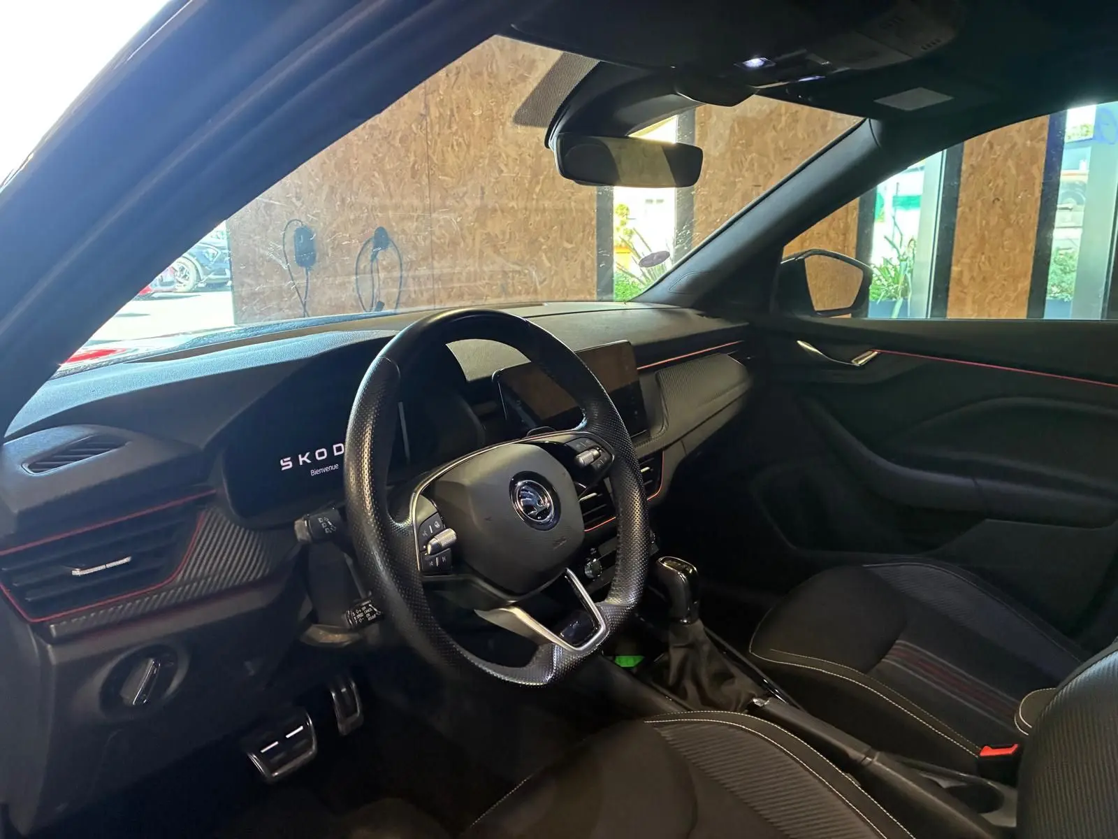 Intérieur noir du Skoda Kamiq 1.5 TSI 150 DSG7 2024, vue côté conducteur avec tableau de bord et volant sport.