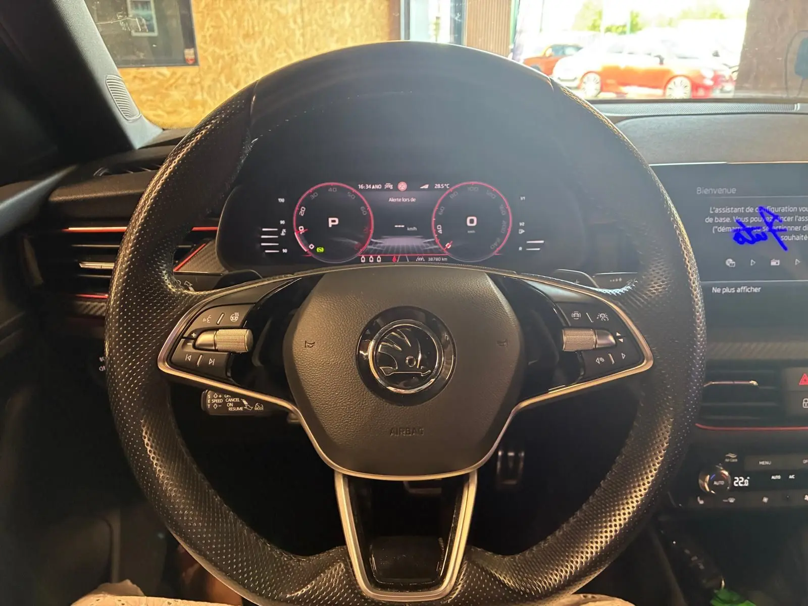 Vue centrée sur le volant perforé noir du Skoda Kamiq 2024 avec tableau de bord numérique et écran multimédia.