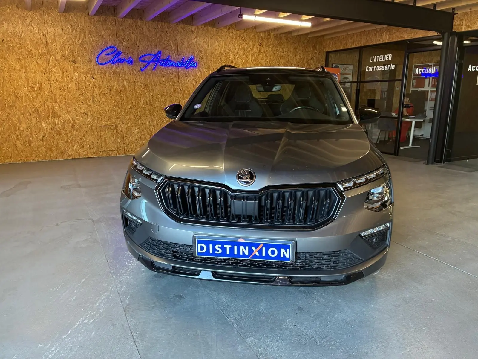 Vue frontale d'un Skoda Kamiq 1.5 TSI 150 DSG7 Monte-Carlo gris foncé, avec calandre noire et éclairage LED.